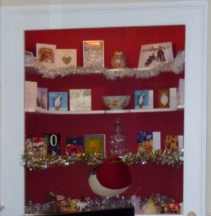 Tinselled shelves with cards and felt robin